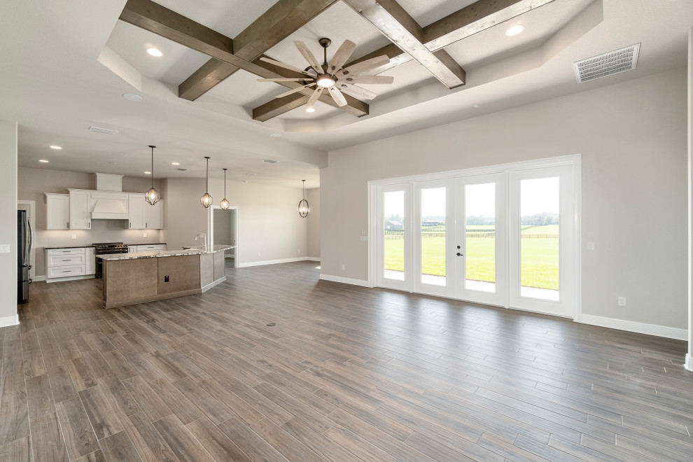 Mid-sized country open concept living room in Other with porcelain floors, brown floor and coffered.