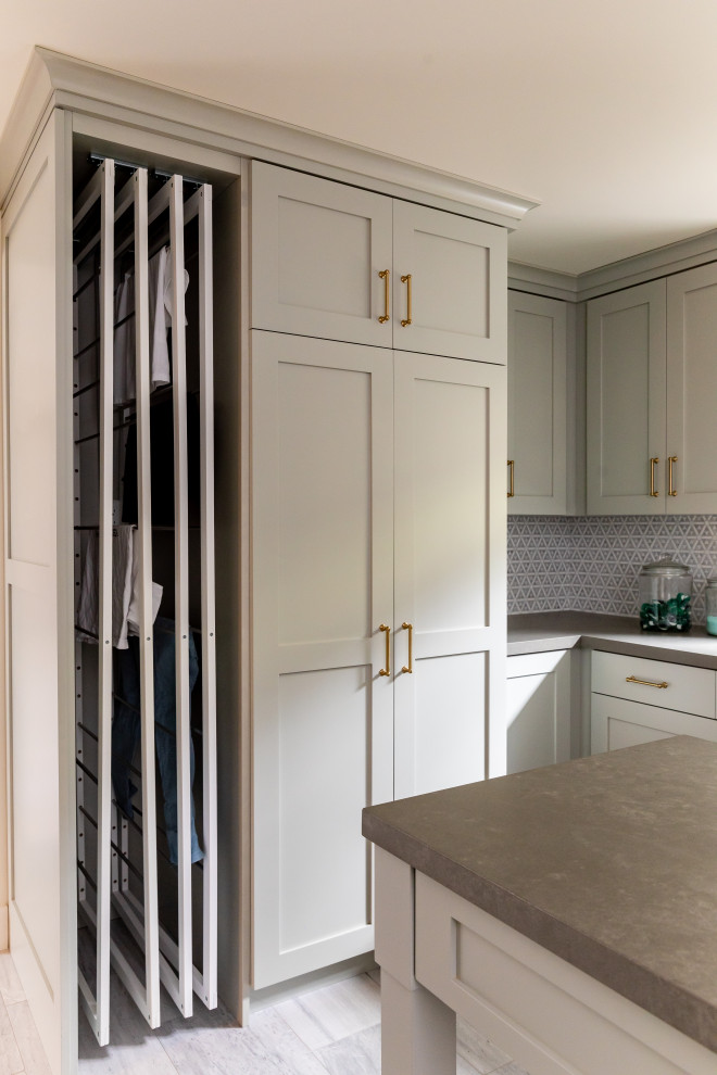This is an example of a large u-shaped dedicated laundry room in Salt Lake City with an undermount sink, shaker cabinets, green cabinets, quartzite benchtops, mosaic tile splashback, marble floors, an integrated washer and dryer, grey floor and grey benchtop.