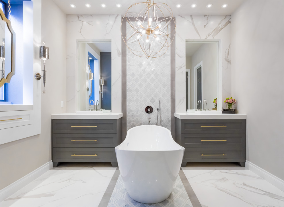 Inspiration for a mid-sized transitional master bathroom in Houston with grey cabinets, a freestanding tub, white tile, porcelain tile, grey walls, marble floors, quartzite benchtops, a curbless shower, a wall-mount toilet, a vessel sink and shaker cabinets.