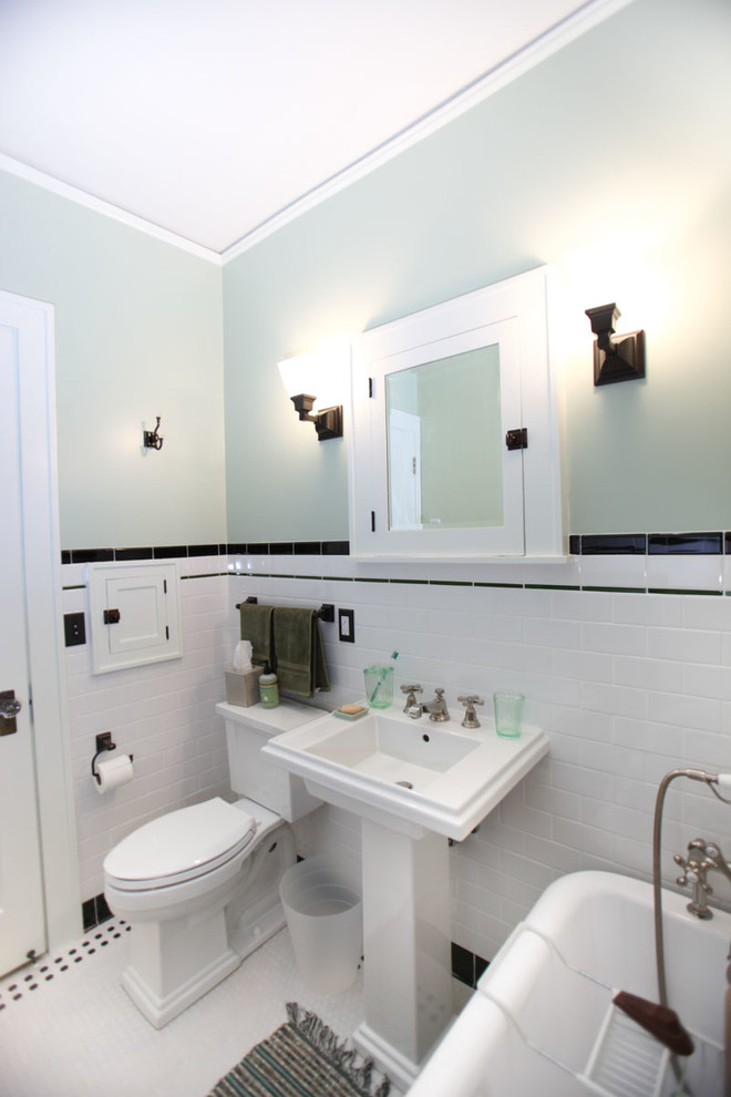 Photo of an arts and crafts bathroom in Minneapolis with a pedestal sink, shaker cabinets, white cabinets, a claw-foot tub, a two-piece toilet, white tile and ceramic tile.