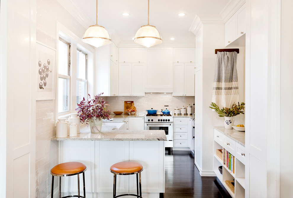 Design ideas for a mid-sized transitional u-shaped kitchen in New York with a farmhouse sink, shaker cabinets, white cabinets, granite benchtops, ceramic splashback, stainless steel appliances, dark hardwood floors, a peninsula and beige splashback.
