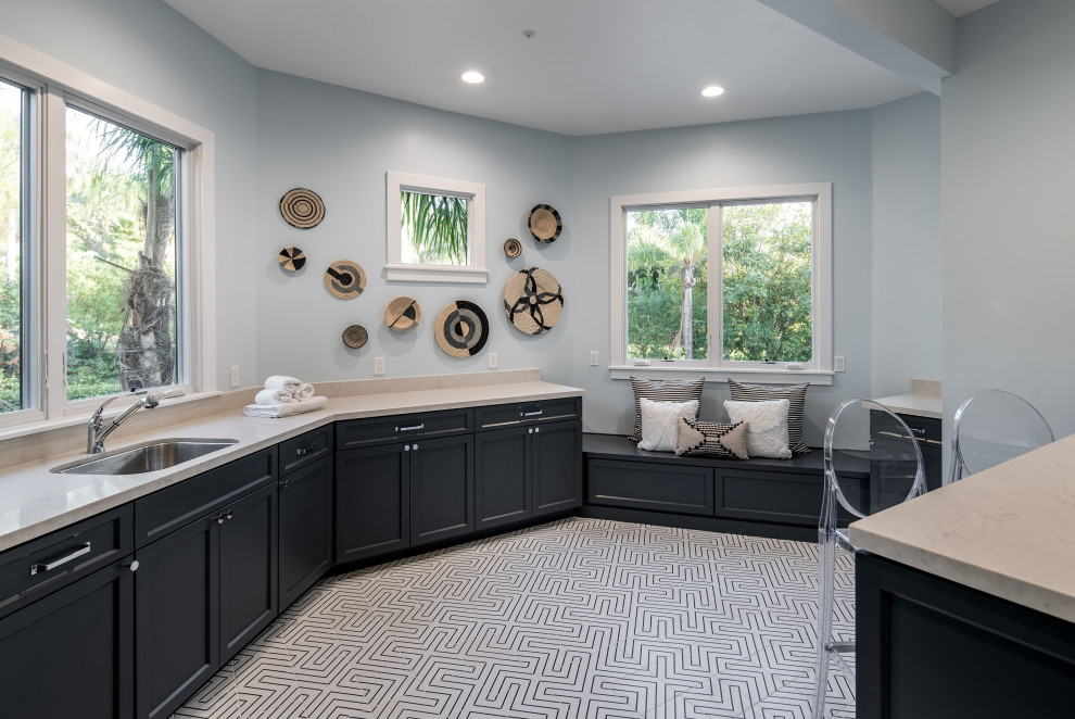 Design ideas for an expansive mediterranean utility room in San Diego with a single-bowl sink, shaker cabinets, blue cabinets, quartzite benchtops, blue walls, ceramic floors, a side-by-side washer and dryer, white floor and beige benchtop.