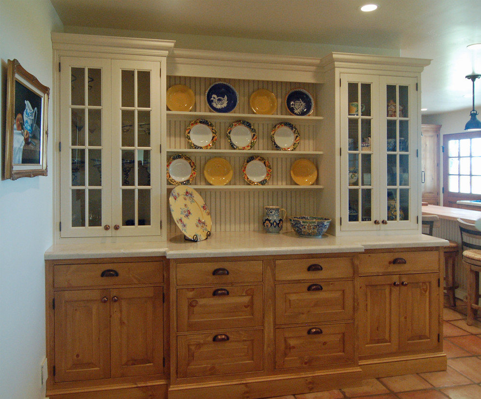This is an example of a large country l-shaped separate kitchen in San Luis Obispo with a farmhouse sink, beaded inset cabinets, white cabinets, limestone benchtops, white splashback, stone tile splashback, stainless steel appliances, terra-cotta floors and with island.
