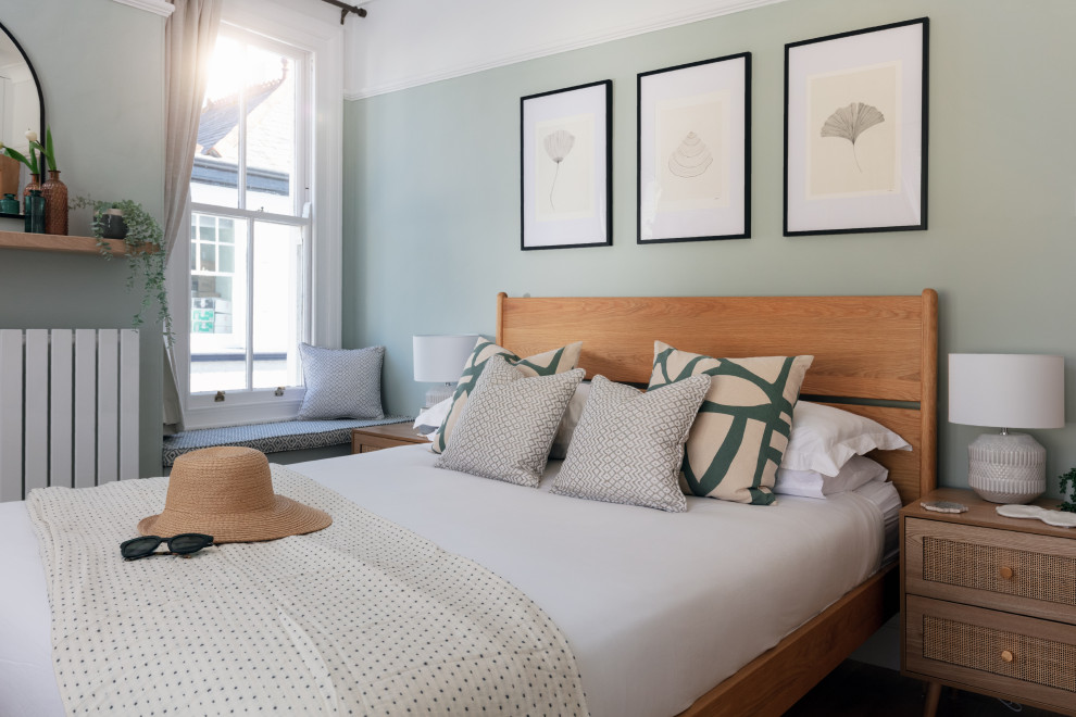 コーンウォールにある中くらいな北欧スタイルのおしゃれな主寝室 (緑の壁、無垢フローリング、暖炉なし、茶色い床) のインテリア