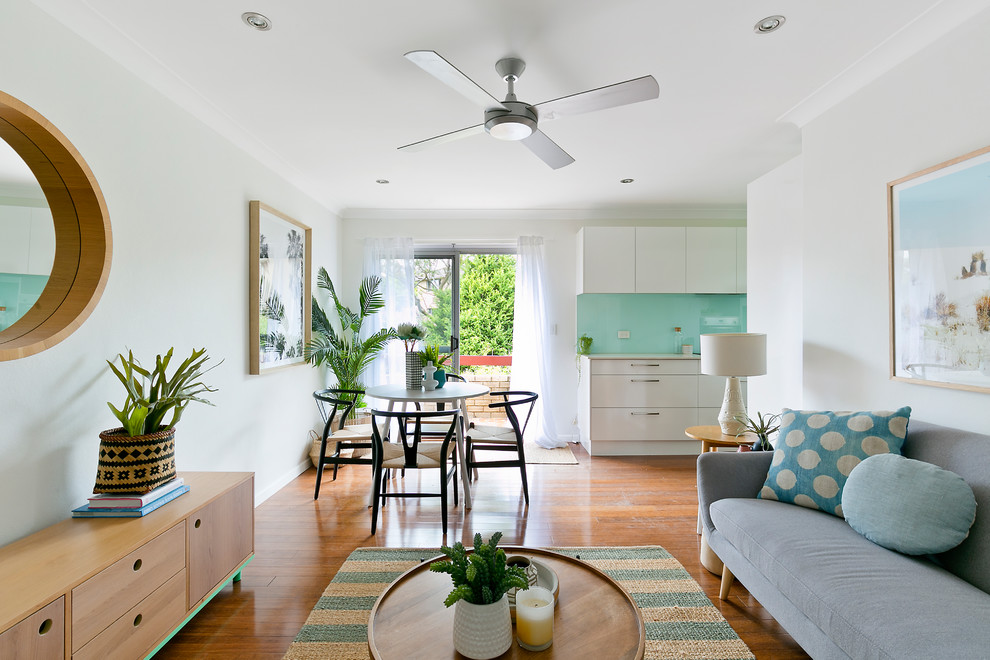 Mid-sized beach style formal open concept living room in Sydney with white walls, medium hardwood floors and brown floor.