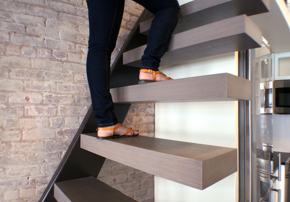 This is an example of a small industrial wood floating staircase in New York with open risers.