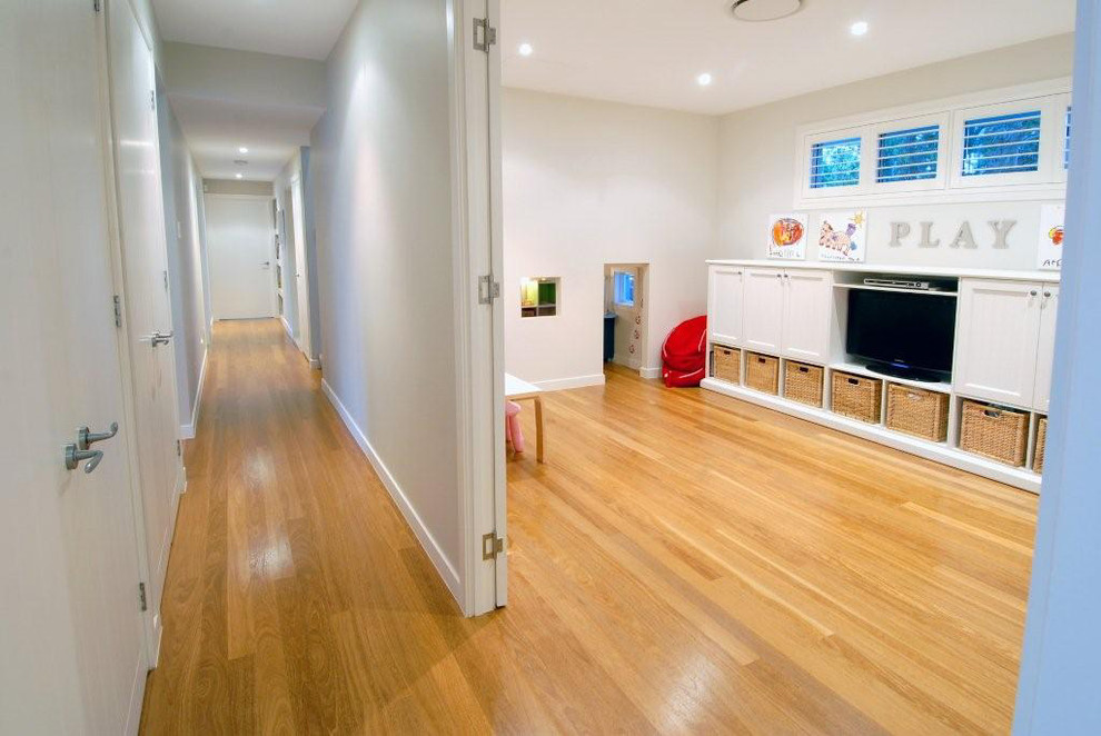 This is an example of a traditional kids' playroom in Brisbane with white walls and light hardwood floors.