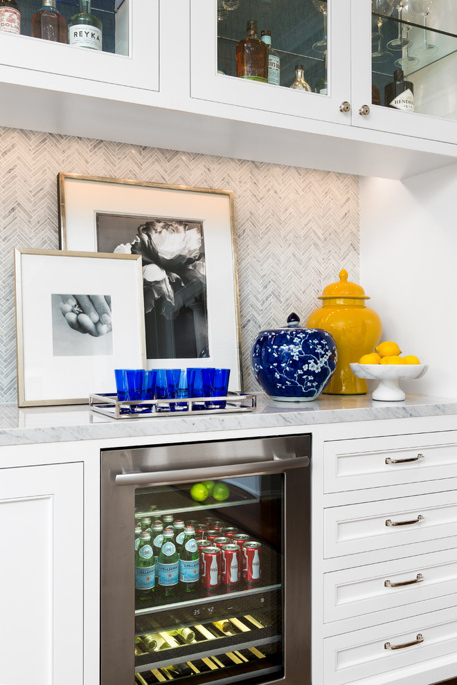 This is an example of a mid-sized transitional single-wall wet bar in Los Angeles with an undermount sink, beaded inset cabinets, white cabinets, marble benchtops, grey splashback, mosaic tile splashback and dark hardwood floors.