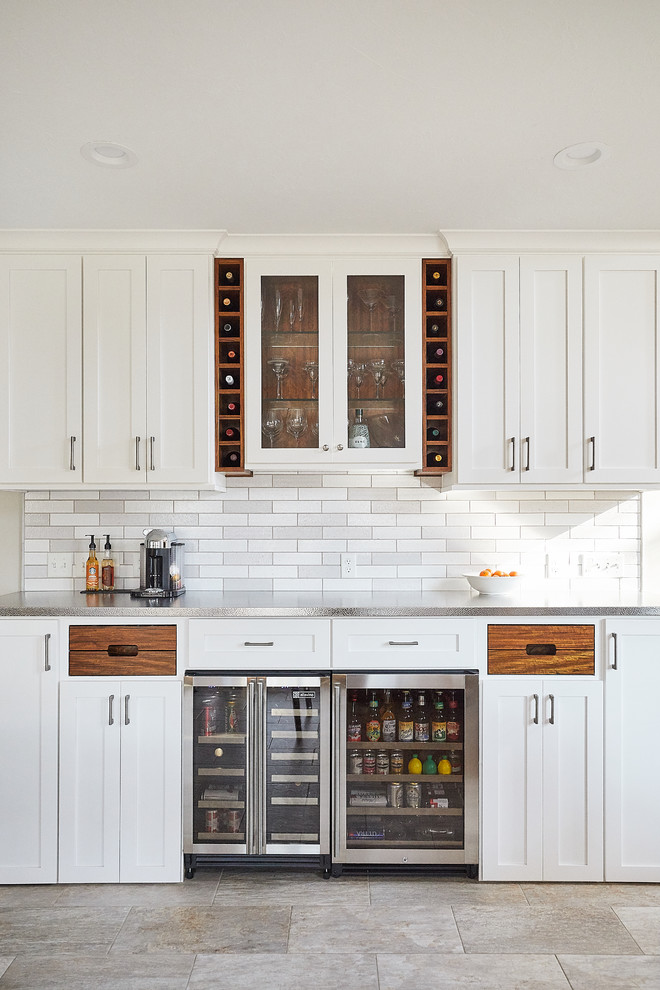 This is an example of a large contemporary u-shaped home bar in Minneapolis with shaker cabinets, white cabinets, quartz benchtops, grey splashback, subway tile splashback, ceramic floors, grey floor and white benchtop.