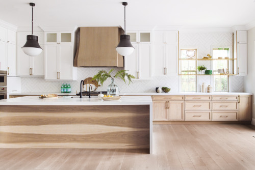 Bright Scandinavian-inspired kitchen with white and light wood kitchen cabinet fronts, large island, and open brass shelving.