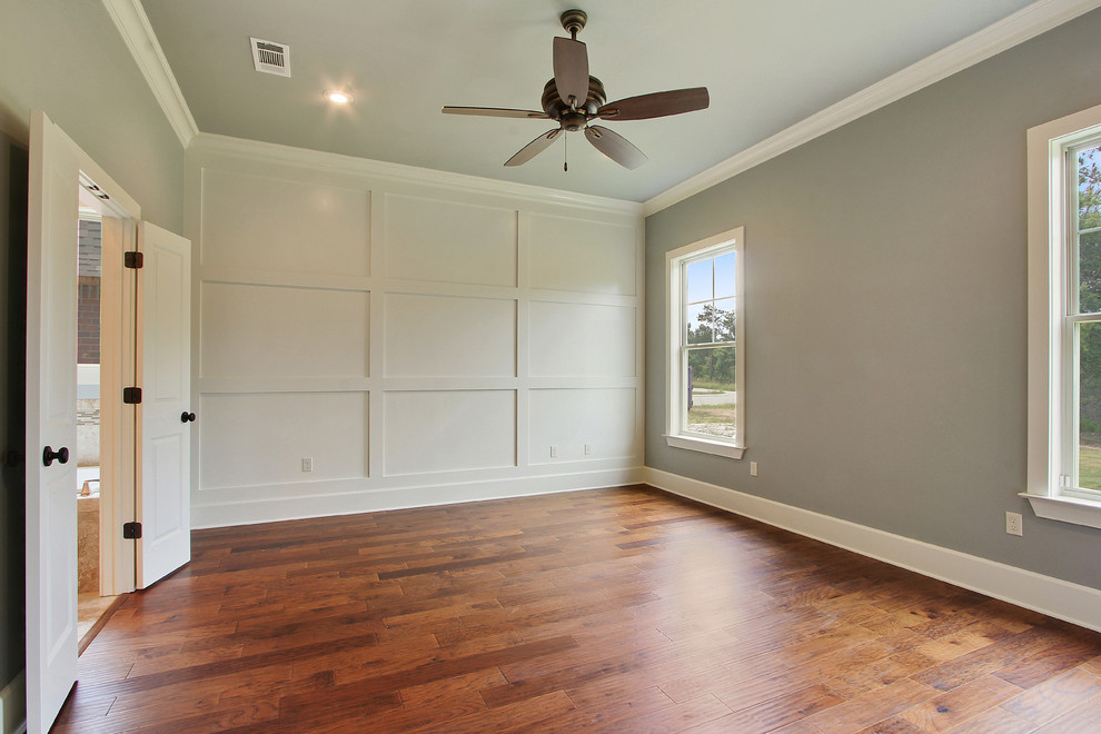 This is an example of a mid-sized contemporary bedroom in New Orleans with grey walls, medium hardwood floors and brown floor.