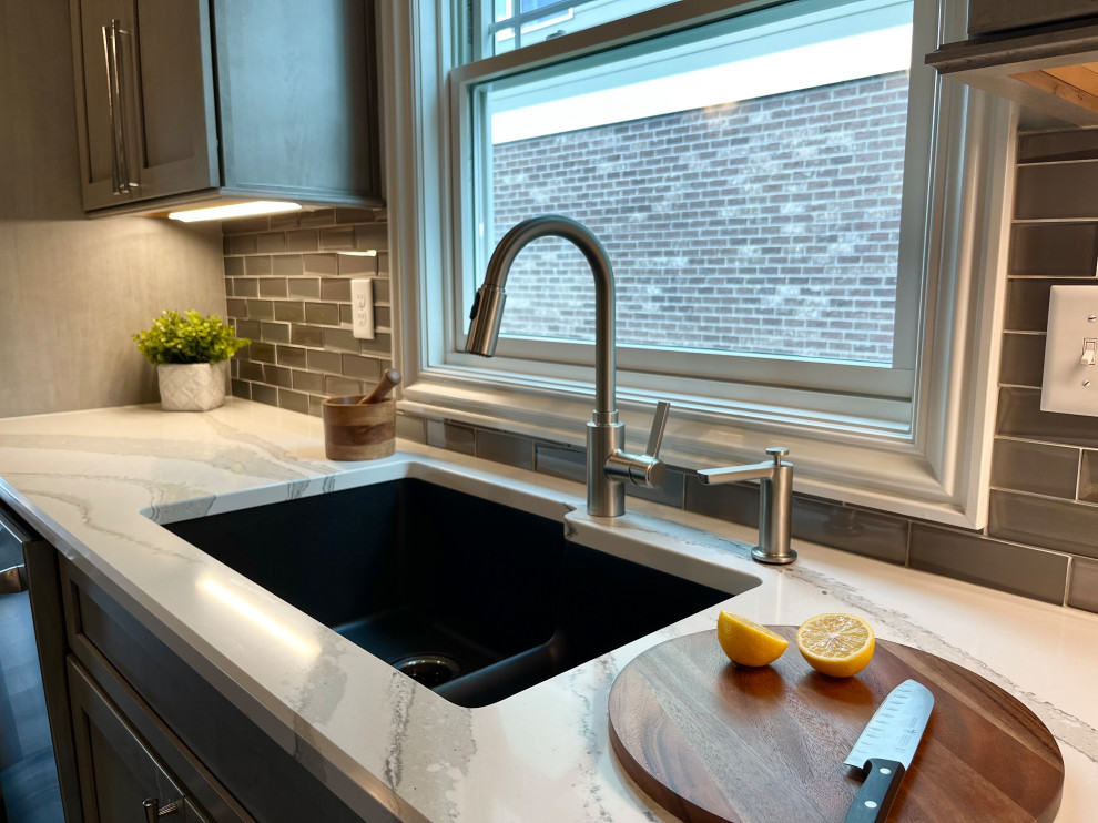 Eat-in kitchen - mid-sized transitional l-shaped dark wood floor and brown floor eat-in kitchen idea with an undermount sink, gray cabinets, quartz countertops, glass tile backsplash, stainless steel appliances, an island, white backsplash and beige countertops