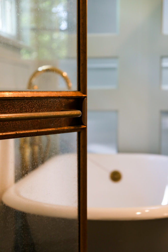 Пример оригинального дизайна: главная ванная комната среднего размера с ванной на ножках, душем в нише, мраморной плиткой, темным паркетным полом, коричневым полом, душем с распашными дверями и панелями на части стены