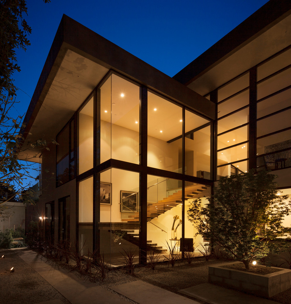 This is an example of a large contemporary two-storey glass house exterior in Los Angeles with a shed roof.