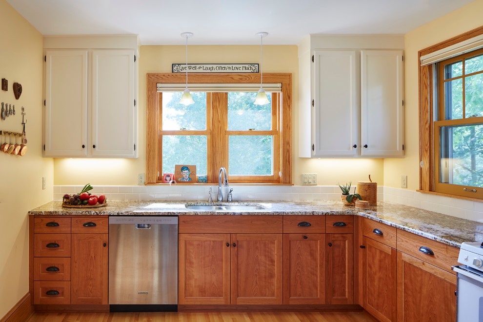 Design ideas for a small arts and crafts u-shaped separate kitchen in Minneapolis with an undermount sink, flat-panel cabinets, medium wood cabinets, granite benchtops, white splashback, ceramic splashback, stainless steel appliances, light hardwood floors and no island.