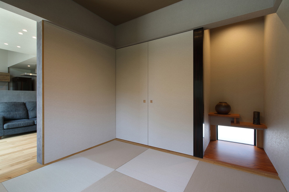 Réalisation d'une salle de séjour minimaliste de taille moyenne avec un mur gris, un sol de tatami, aucune cheminée, aucun téléviseur, un sol beige, un plafond décaissé, du papier peint et canapé noir.
