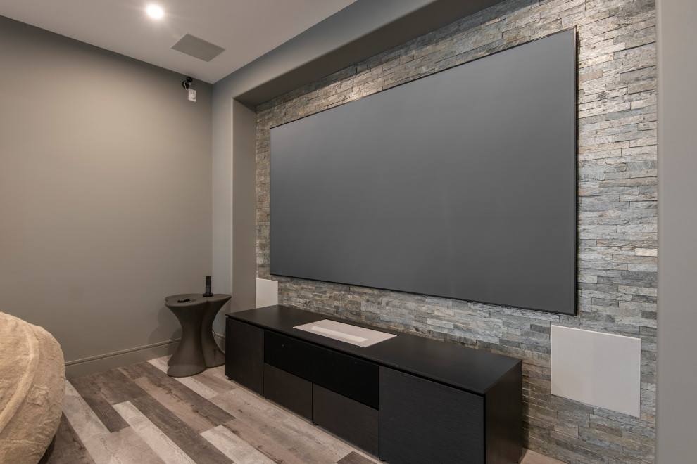 Photo of a large farmhouse home cinema in Philadelphia with laminate floors, a projector screen and beige floors.