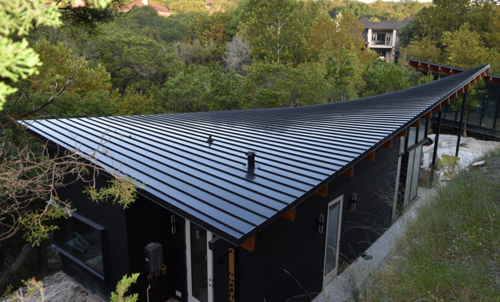 Design ideas for a modern exterior in Austin with a flat roof, a metal roof and a black roof.
