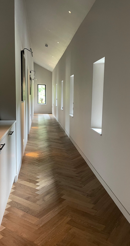 Idee per un ingresso o corridoio minimal di medie dimensioni con pareti beige, pavimento in legno massello medio, pavimento marrone e soffitto a volta