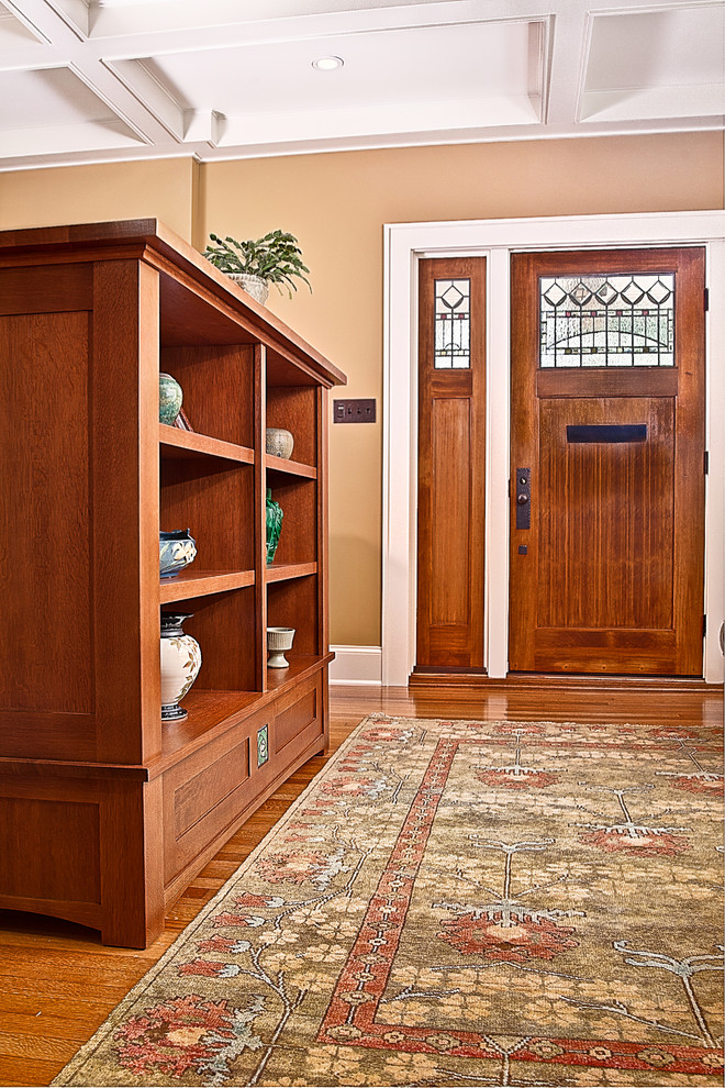 This is an example of a mid-sized arts and crafts entryway in Charlotte with yellow walls and medium hardwood floors.