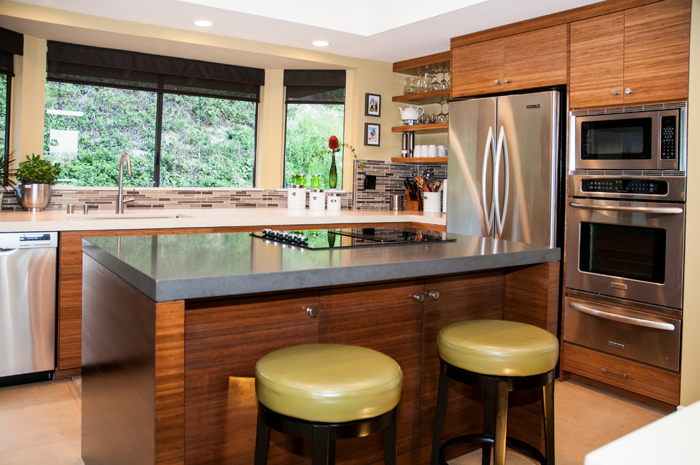 Photo of a mid-sized contemporary u-shaped eat-in kitchen in Orange County with a single-bowl sink, flat-panel cabinets, medium wood cabinets, quartz benchtops, grey splashback, stainless steel appliances, porcelain floors, with island, matchstick tile splashback and beige floor.