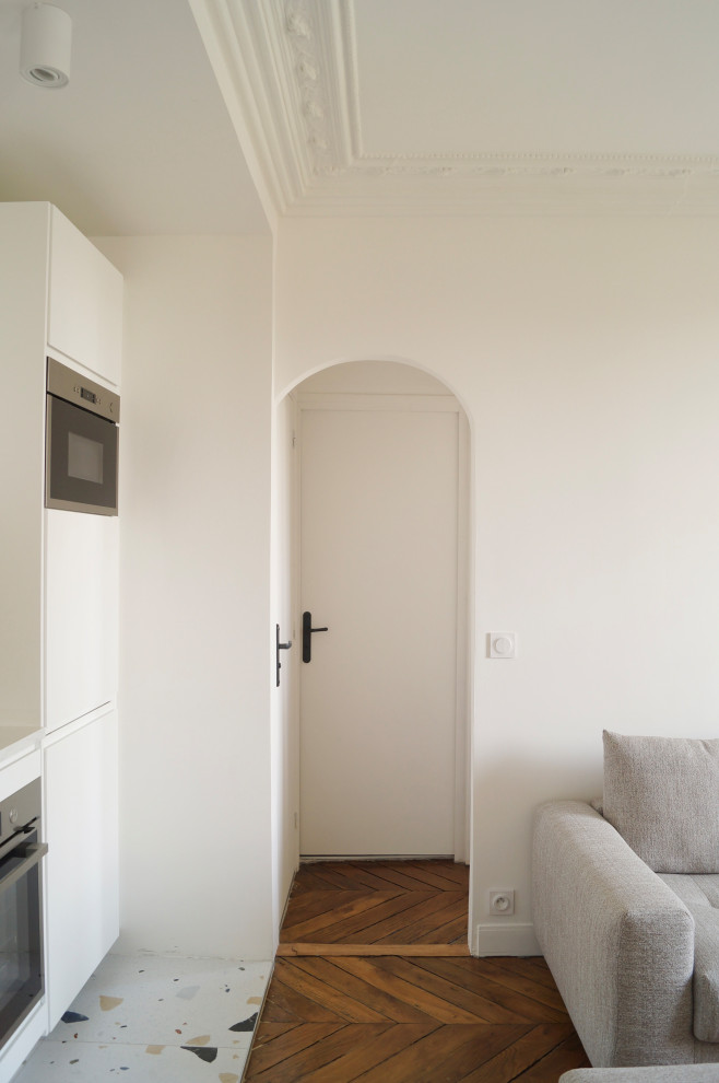 Cette photo montre un couloir moderne de taille moyenne avec un mur blanc et parquet clair.