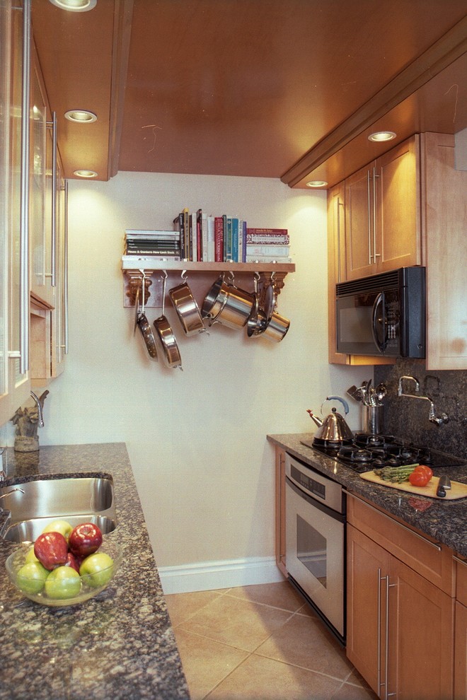 Inspiration for a small transitional galley ceramic tile kitchen remodel in Miami with an undermount sink, shaker cabinets, medium tone wood cabinets, granite countertops, black backsplash, stone slab backsplash and stainless steel appliances