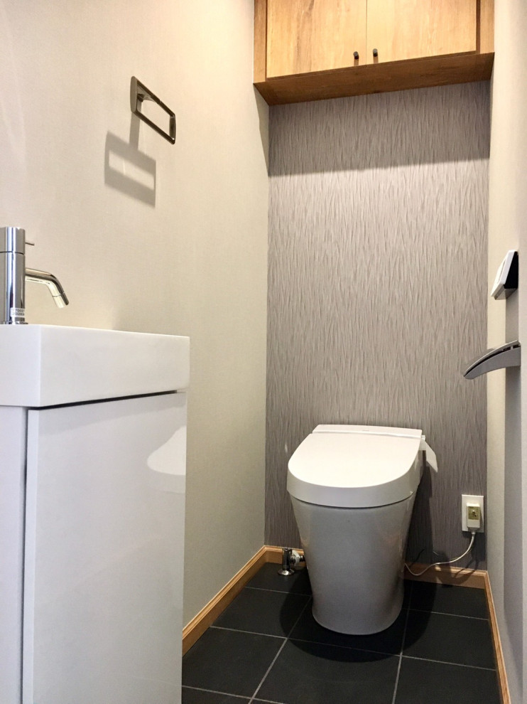 Пример оригинального дизайна: туалет в стиле модернизм с унитазом-моноблоком, серыми стенами, полом из керамической плитки, черным полом, потолком с обоями и обоями на стенах