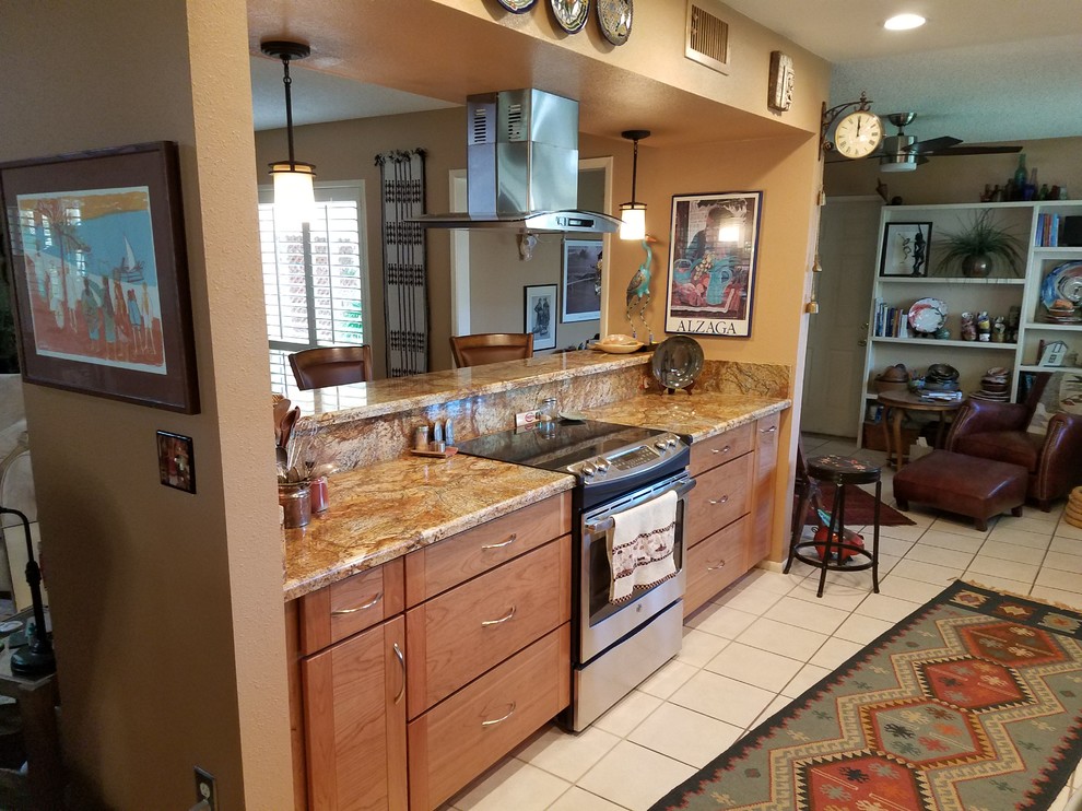 Inspiration for a large transitional galley ceramic tile kitchen remodel in Phoenix with a double-bowl sink, flat-panel cabinets, medium tone wood cabinets, granite countertops, stainless steel appliances and an island