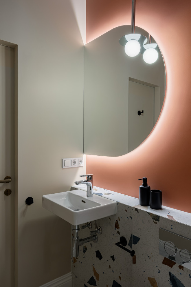 Immagine di un bagno di servizio chic di medie dimensioni con WC sospeso, piastrelle verdi, piastrelle in ceramica, pareti arancioni, pavimento in gres porcellanato, lavabo sospeso e pavimento multicolore