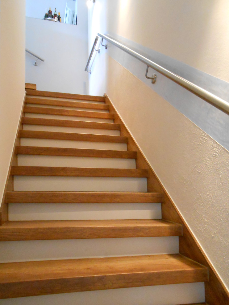 Mittelgroße Mediterrane Holztreppe in L-Form mit Beton-Setzstufen und Stahlgeländer in Essen