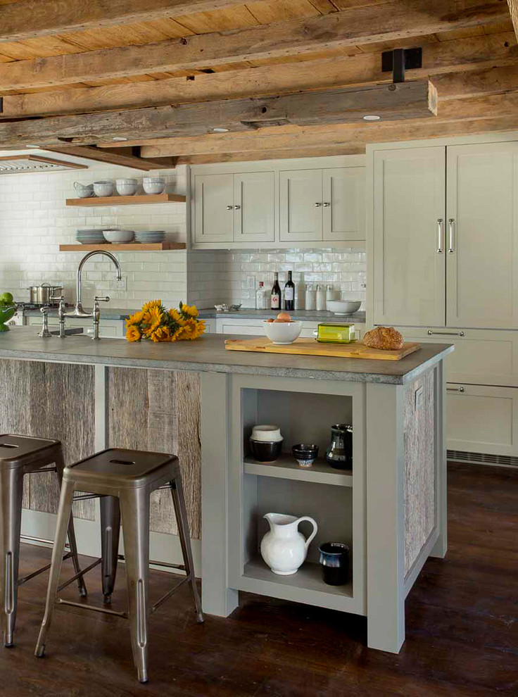 Design ideas for a small country galley eat-in kitchen in Boston with a farmhouse sink, recessed-panel cabinets, grey cabinets, soapstone benchtops, white splashback, ceramic splashback, stainless steel appliances, dark hardwood floors and with island.