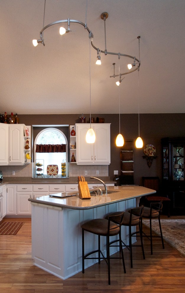 Inspiration for a mid-sized traditional l-shaped separate kitchen in Minneapolis with a double-bowl sink, raised-panel cabinets, white cabinets, granite benchtops, beige splashback, stone tile splashback, white appliances, medium hardwood floors and with island.