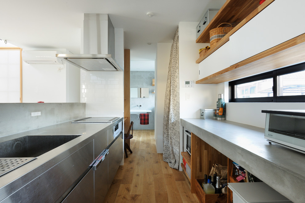 他の地域にあるアジアンスタイルのおしゃれなII型キッチン (一体型シンク、フラットパネル扉のキャビネット、ステンレスキャビネット、ステンレスカウンター、白いキッチンパネル、ガラスまたは窓のキッチンパネル、シルバーの調理設備、茶色い床、グレーのキッチンカウンター、淡色無垢フローリング) の写真