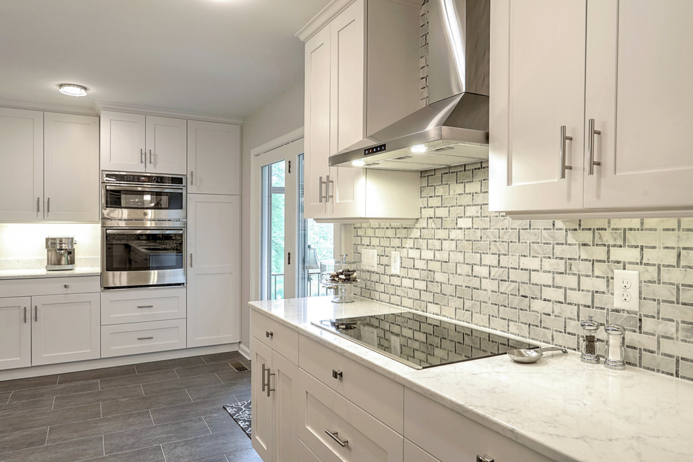Example of a large transitional eat-in kitchen design with shaker cabinets, white cabinets, quartz countertops, gray backsplash, marble backsplash and an island