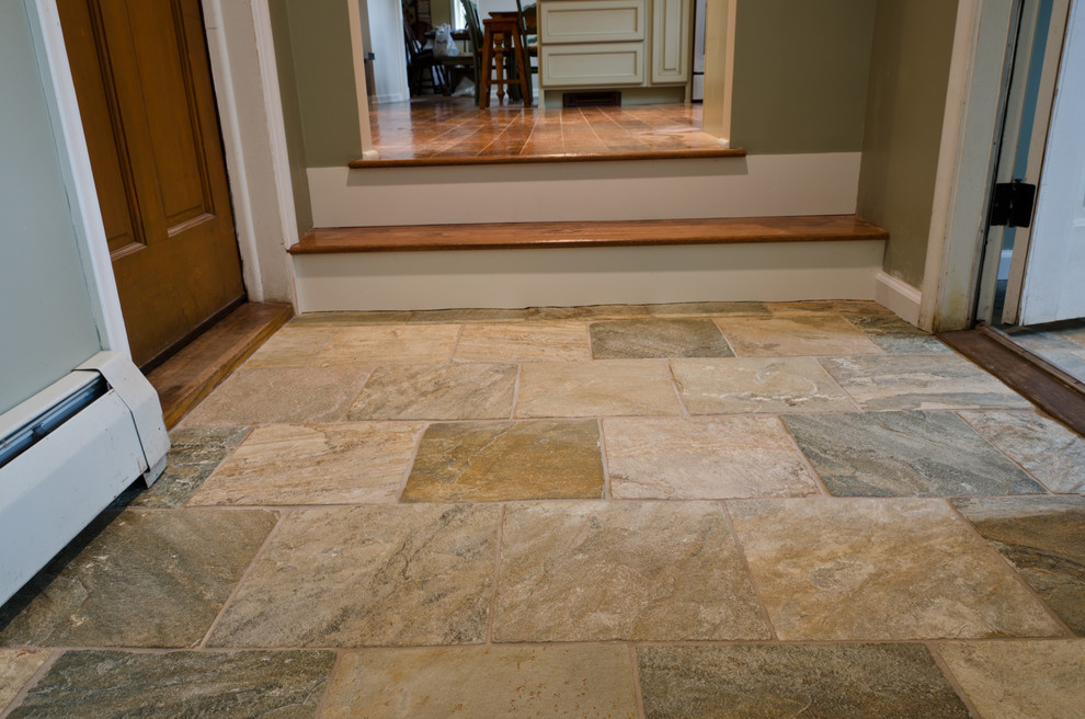 Small transitional travertine floor foyer photo with beige walls and a dark wood front door