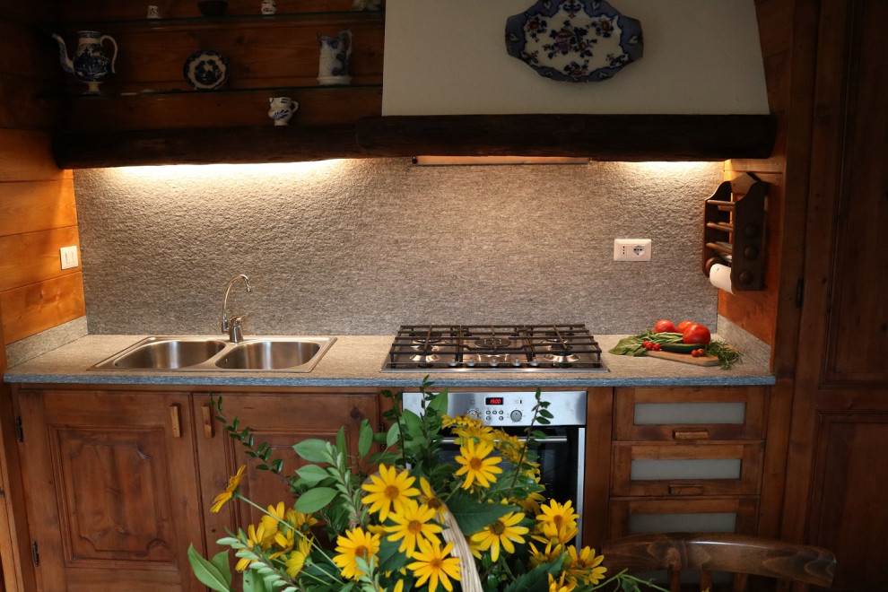 Country eat-in kitchen in Milan with light wood cabinets.