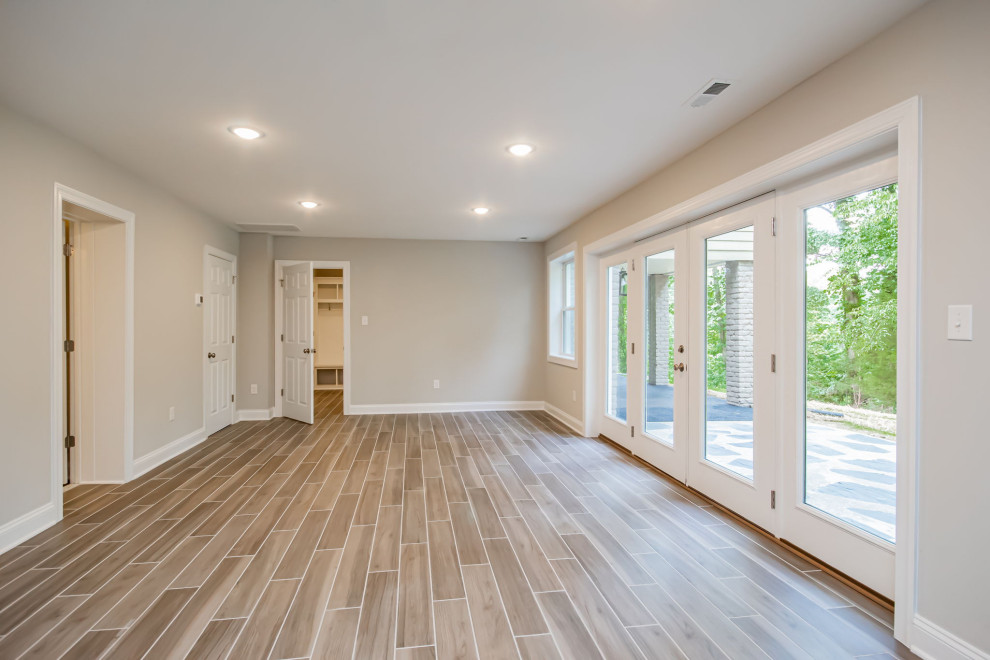 Inspiration for a mid-sized traditional walk-out basement in Richmond with a game room, grey walls, ceramic floors and brown floor.