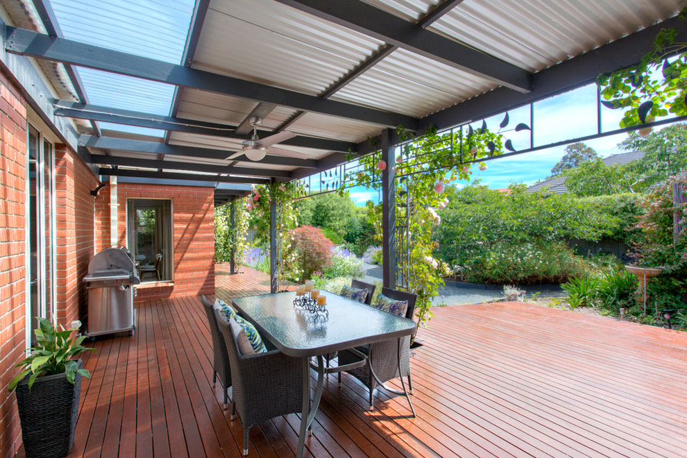 Design ideas for an expansive contemporary backyard deck in Other with a roof extension.
