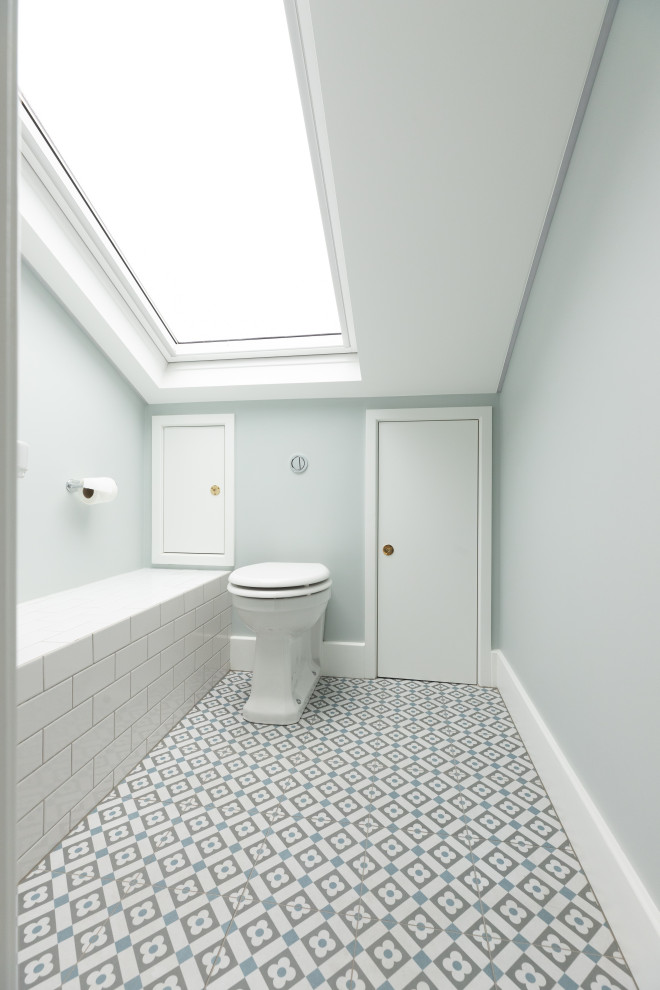 Inredning av ett klassiskt litet en-suite badrum, med vita skåp, vit kakel, keramikplattor, klinkergolv i keramik och flerfärgat golv