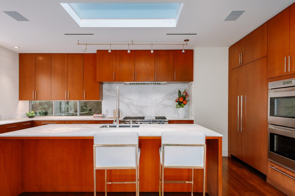 Design ideas for an expansive modern u-shaped separate kitchen in Los Angeles with flat-panel cabinets, medium wood cabinets, marble benchtops, white splashback, marble splashback, stainless steel appliances, with island and white benchtop.
