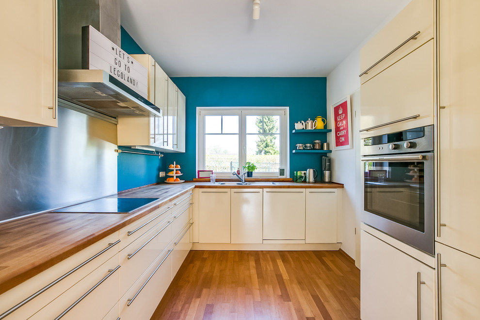 Esempio di una cucina minimalista di medie dimensioni con ante a persiana, ante bianche, top in legno, paraspruzzi blu e nessuna isola