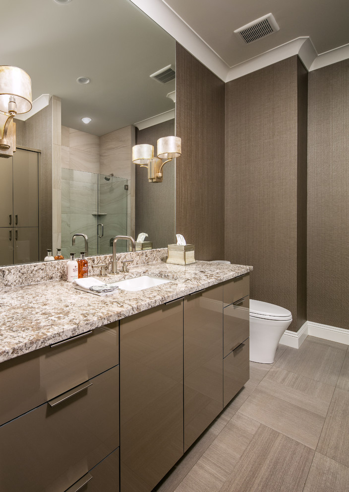 Example of a mid-sized transitional 3/4 beige tile and porcelain tile porcelain tile and beige floor alcove shower design in Omaha with flat-panel cabinets, dark wood cabinets, brown walls, an undermount sink, granite countertops and a hinged shower door