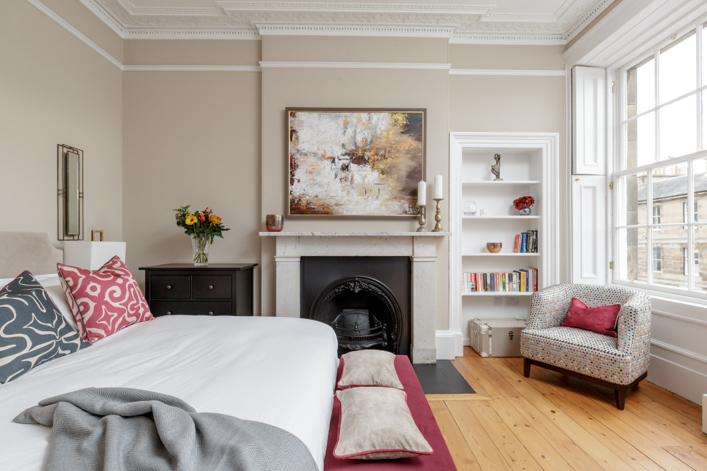 Photo of a classic master bedroom in Other with beige walls, light hardwood flooring, a standard fireplace, beige floors and a chimney breast.