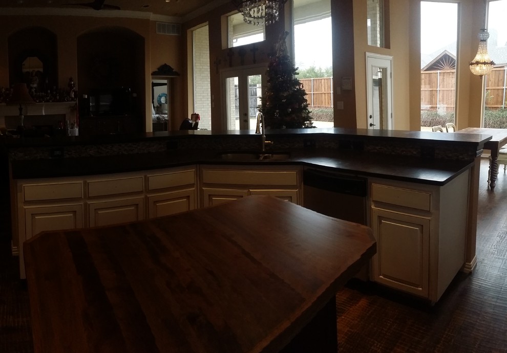 Large transitional brown floor open concept kitchen photo in Dallas with an undermount sink, raised-panel cabinets, white cabinets, granite countertops, gray backsplash, stone tile backsplash, stainless steel appliances and an island