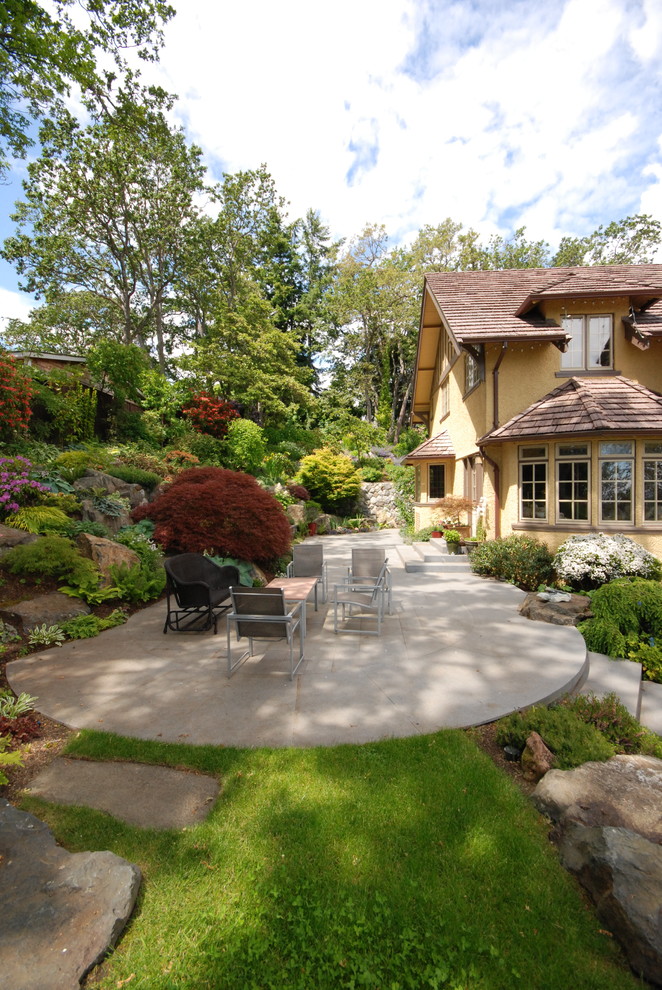 Large traditional side yard patio in Vancouver with natural stone pavers.