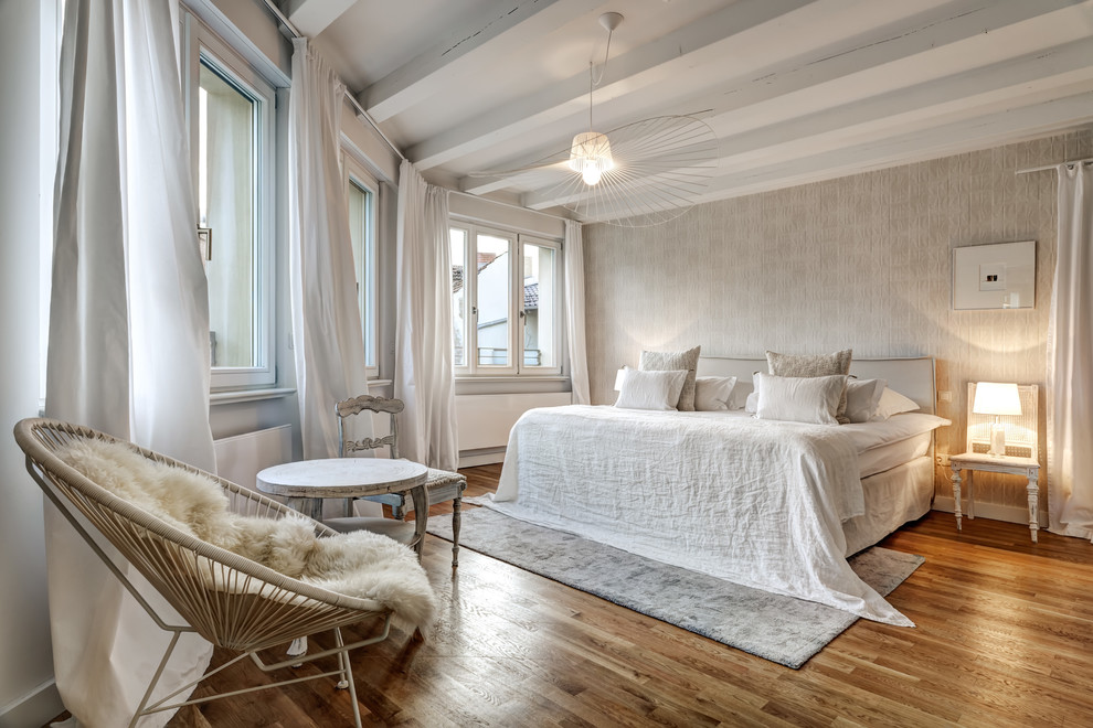 Photo of a large beach style master bedroom in Berlin with beige walls, medium hardwood floors, no fireplace and brown floor.