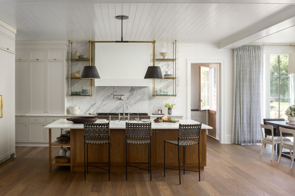 Aménagement d'une grande cuisine américaine linéaire classique avec des portes de placard beiges, une crédence multicolore, un électroménager en acier inoxydable, un sol en bois brun, îlot, un sol marron et un plafond en lambris de bois.