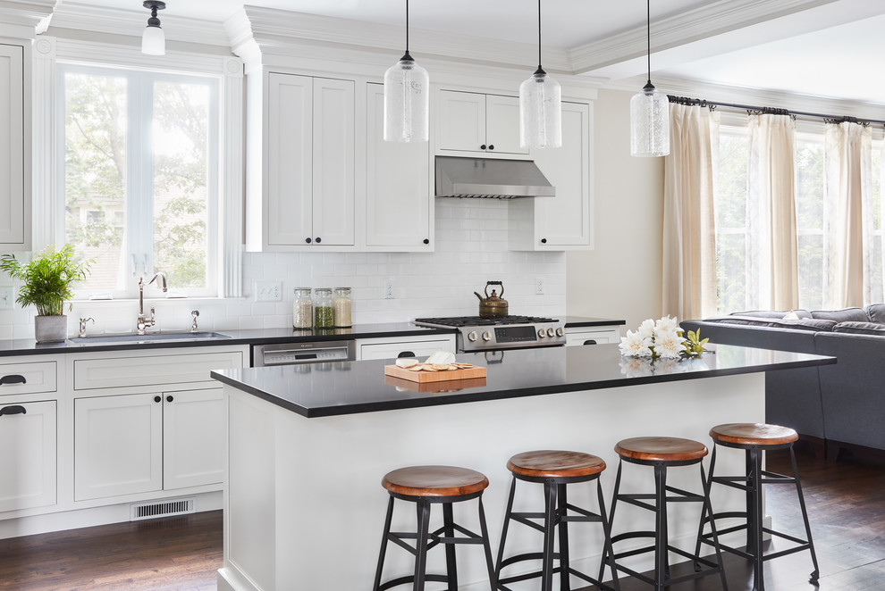 Open concept kitchen - large transitional l-shaped dark wood floor and brown floor open concept kitchen idea in Boston with an undermount sink, beaded inset cabinets, white cabinets, quartz countertops, white backsplash, subway tile backsplash, stainless steel appliances and an island