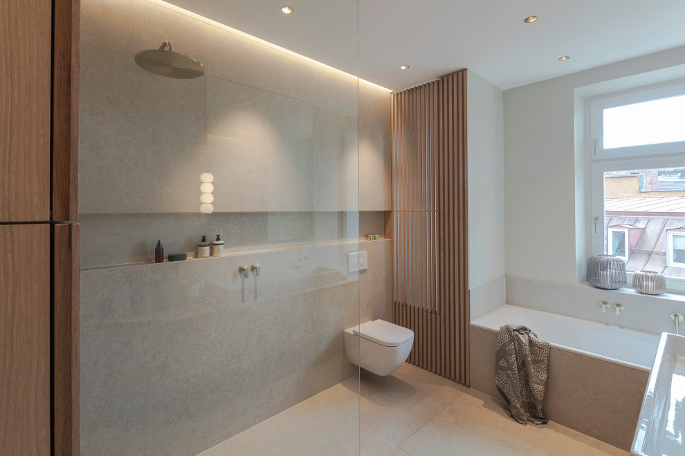 Идея дизайна: большая главная, серо-белая ванная комната в стиле модернизм с плоскими фасадами, светлыми деревянными фасадами, накладной ванной, душем без бортиков, раздельным унитазом, бежевой плиткой, керамической плиткой, серыми стенами, полом из галечной плитки, настольной раковиной, столешницей из дерева, бежевым полом, открытым душем, тумбой под две раковины, подвесной тумбой и деревянными стенами